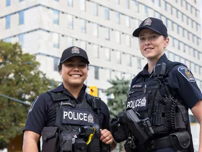 Two Female Officers outside, apartment building in the background