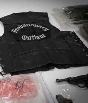 Black leather vest with "probationary outlaw", handgun