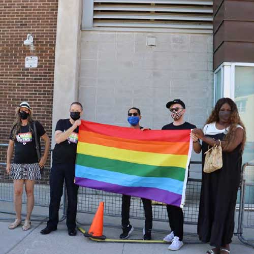 Pride members holding pride flag outside LPS Headquarters