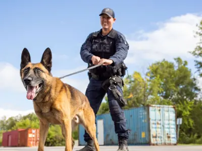 Smiling Canine Officer holding dog on leash