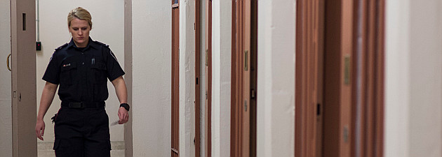 Female cadet walking in front of jail cells