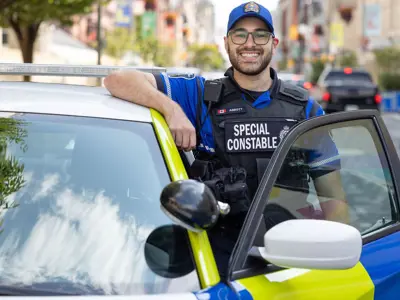 Special Constable standing in drivers side doorway of cruiser