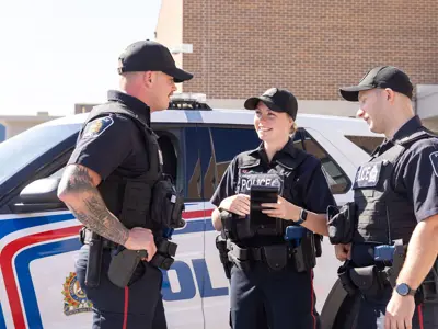 Three LPS officers talking in front of LPS SUV