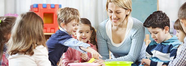 Teacher surrounded by young kids at play table