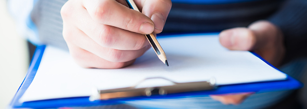 man writing on clipboard