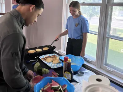Youth In Policing Initiative student serving pancakes