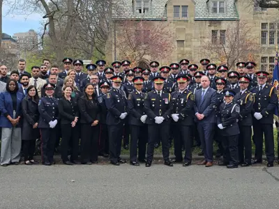 Large group photo of LPS officers and civilians at memorial