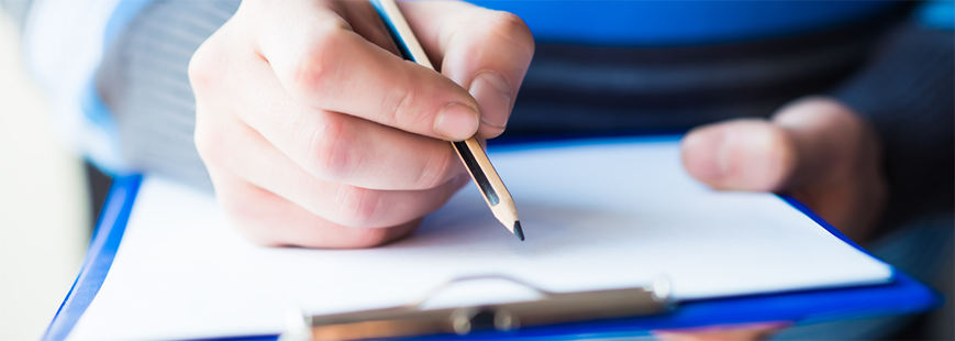 person writing on a pad of paper