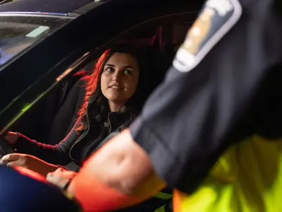 female driver speaking with officer in RIDE program