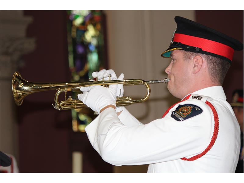 Officer in white uniform playing trumpet